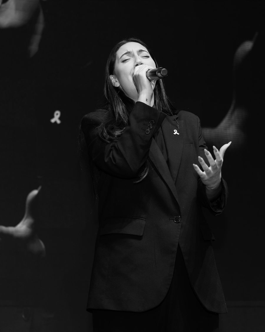 Black and white event photograph of a singer performing on stage.